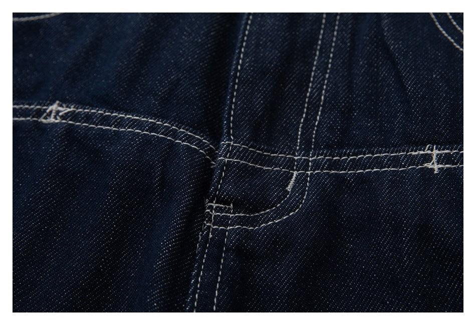 Close-up of a dark indigo jeans seam with intersecting rows of light contrast stitching.