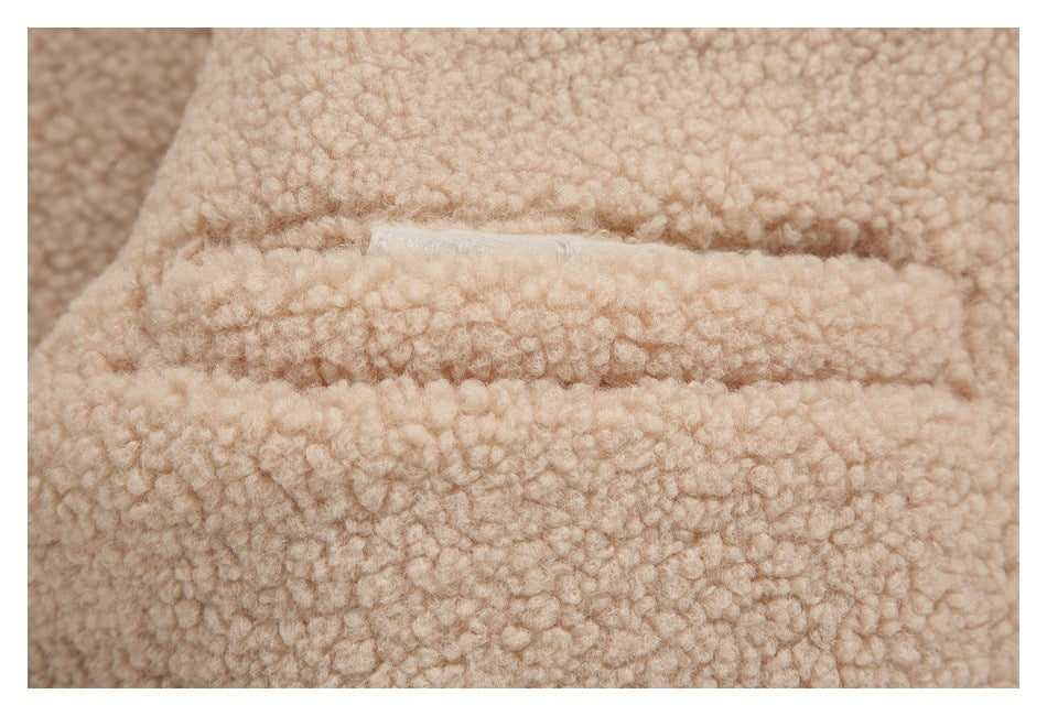 Close-up of cream, curly plush jacket lining with a stitched seam.