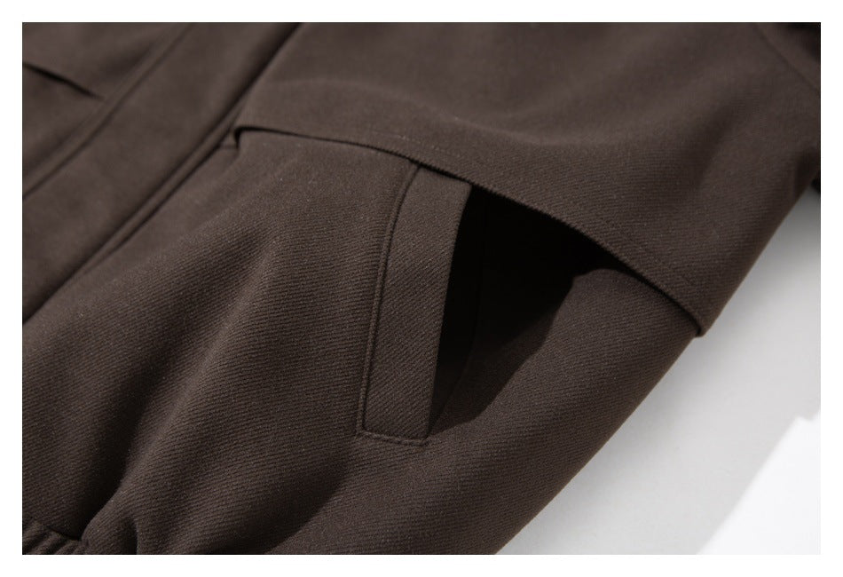 Close-up of a dark brown garment showing a slanted welt pocket.