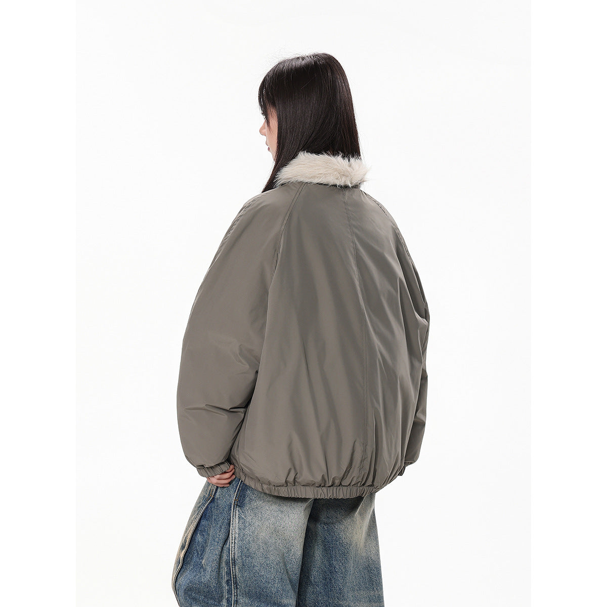 Side and back view of a model wearing a taupe-gray jacket with a cream fur-trimmed collar.