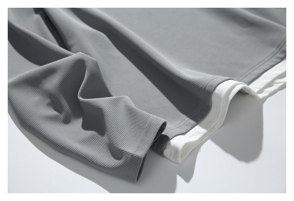 Close-up of the gray textured sleeve and layered white hem.