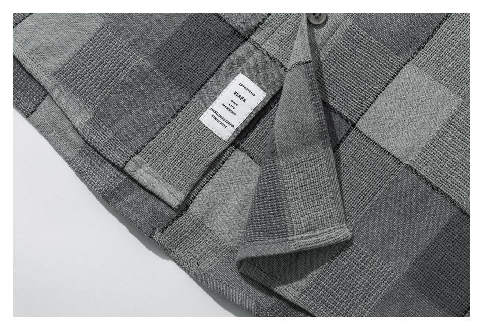 Inside view of the gray patchwork-check shirt showing its sewn-in label and stitching.
