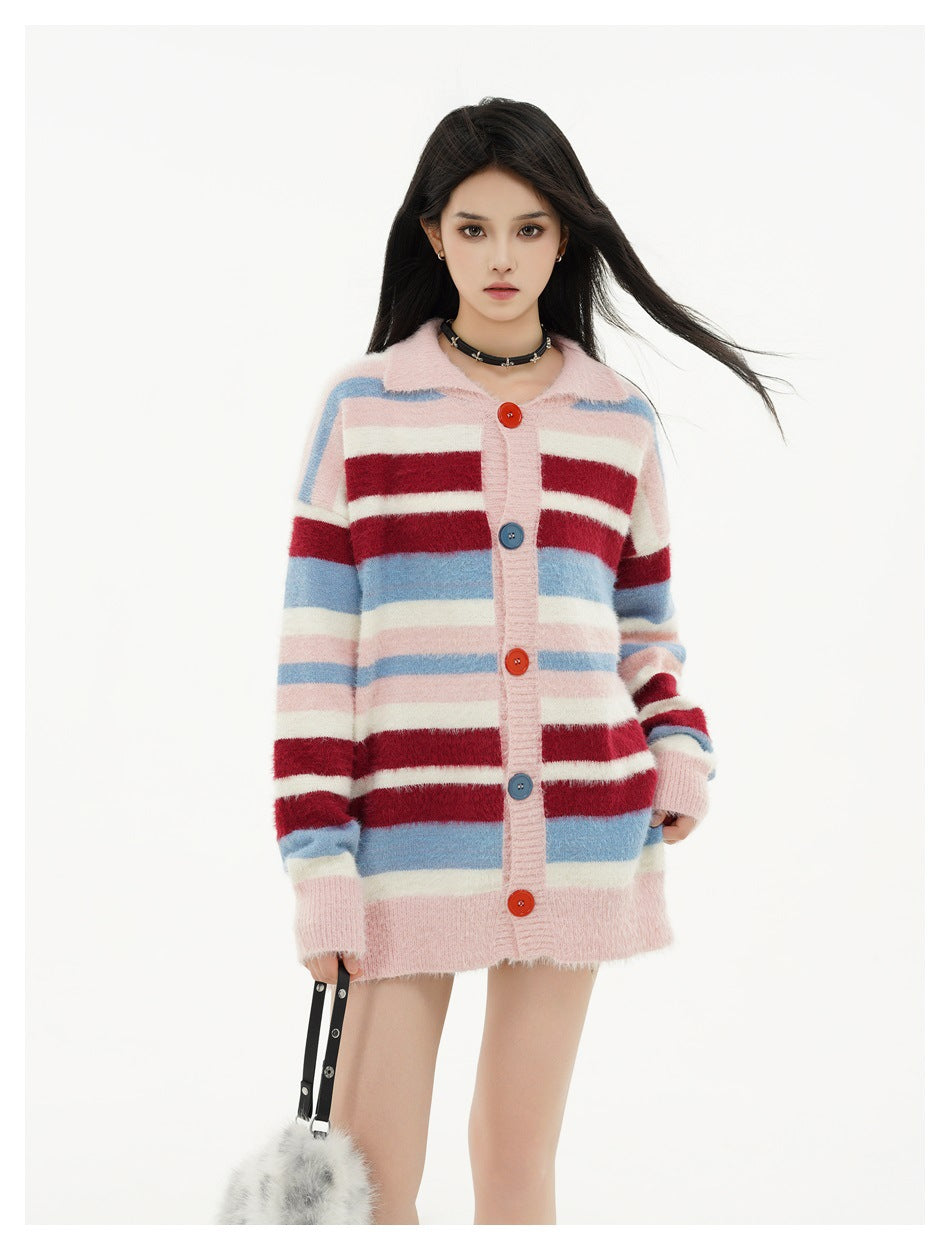 Front view of a model wearing an oversized pink cardigan with blue, burgundy, and cream stripes and colorful buttons.