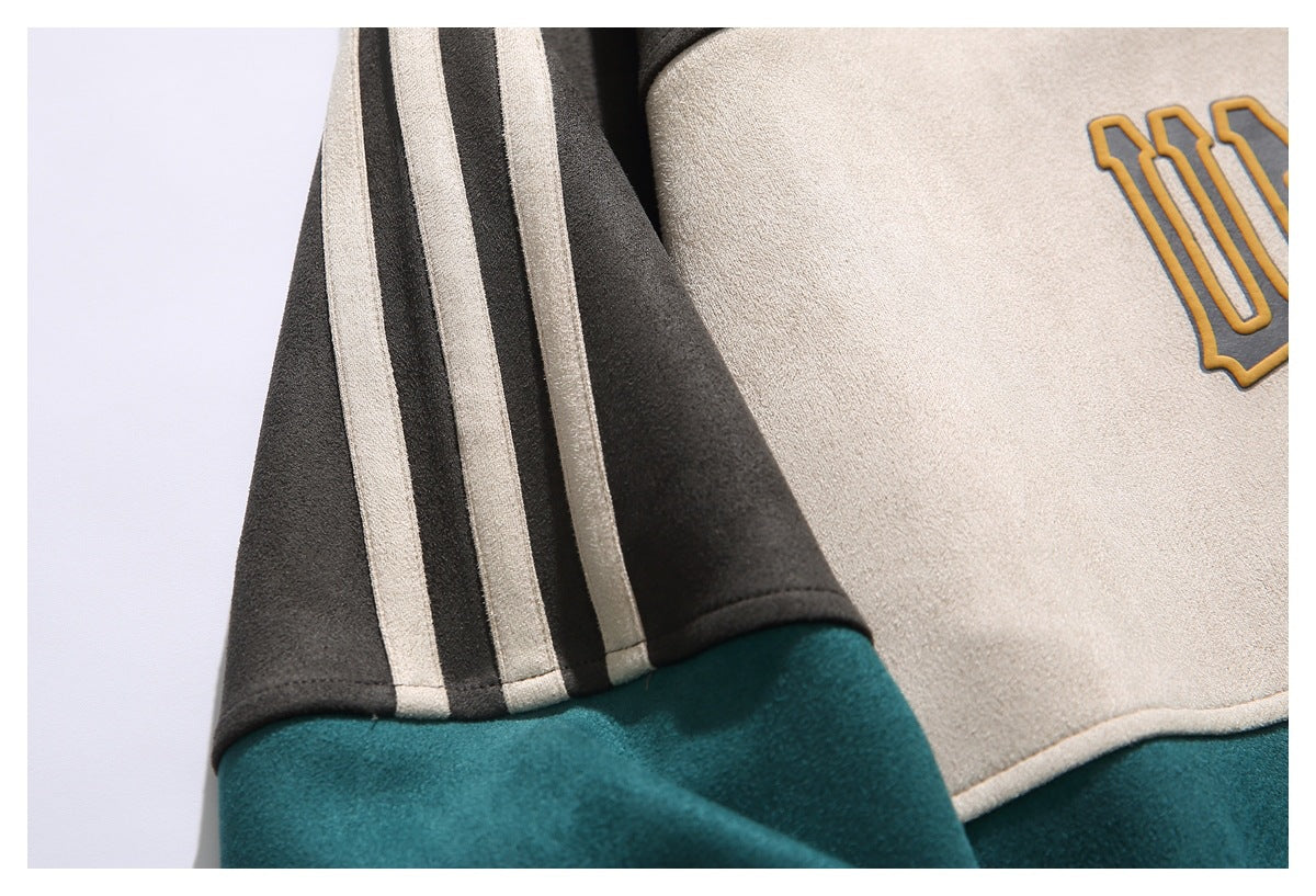 Close-up of a cream and charcoal garment panel with striped sleeve trim and part of a mustard graphic.