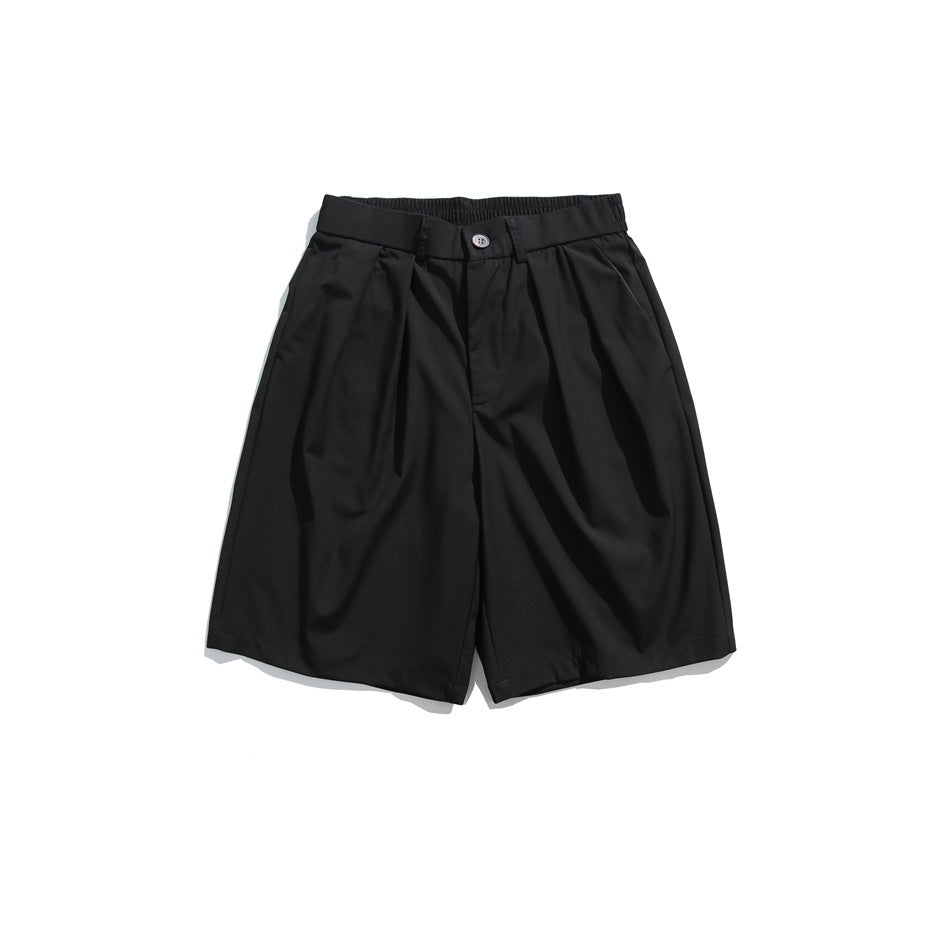 Front view of black pleated knee-length shorts with button closure and elastic waistband