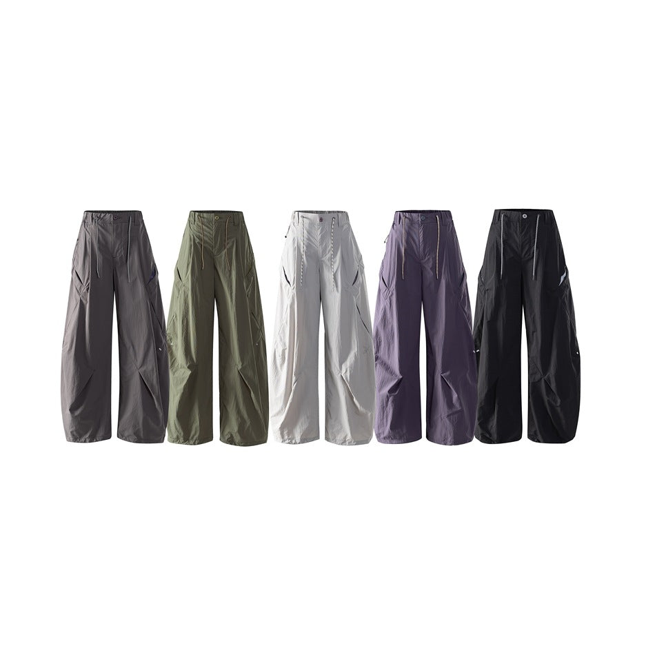 Five pairs of loose wide-leg pants shown together in charcoal, olive, light gray, purple, and black.