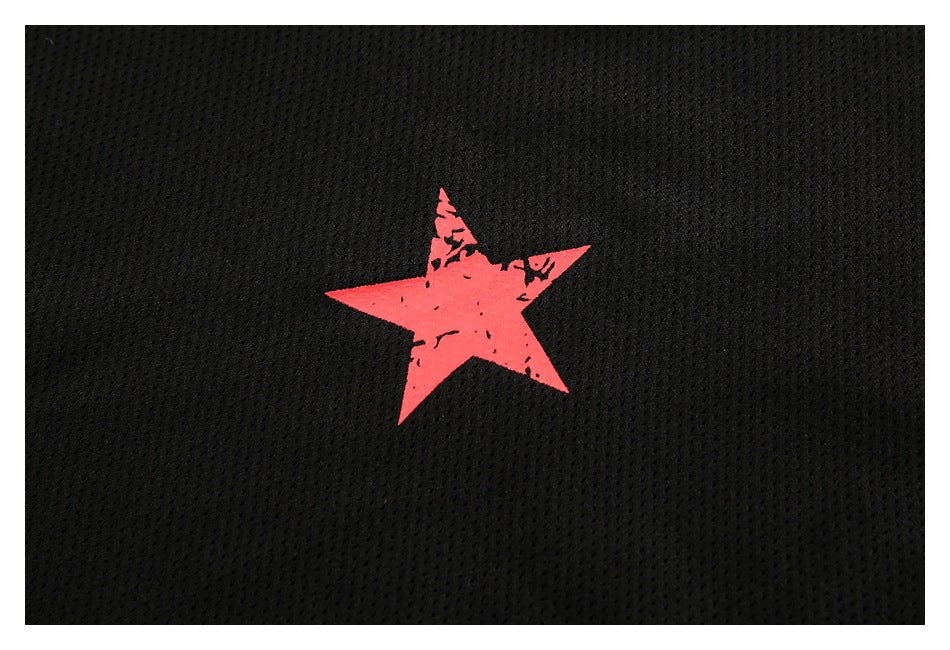 Close-up of a distressed red star graphic on black mesh fabric.