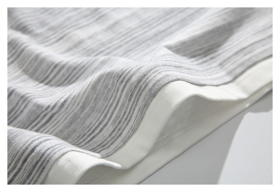 Close-up of gray and white striped fabric finished with a wide white edge.