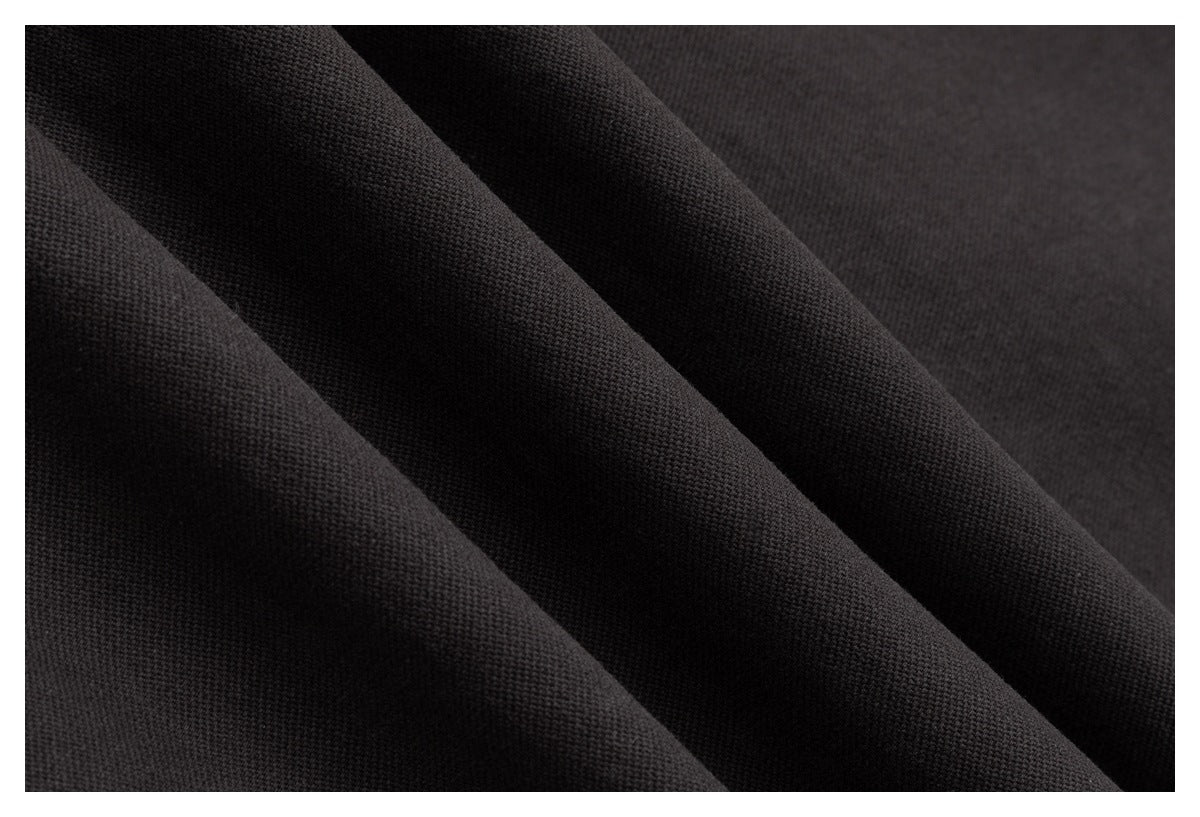 Close-up of black fabric arranged in soft folds, showing a fine textured weave.