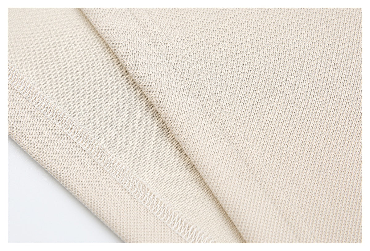Inside view of cream-beige fabric showing an overlocked seam and stitching.