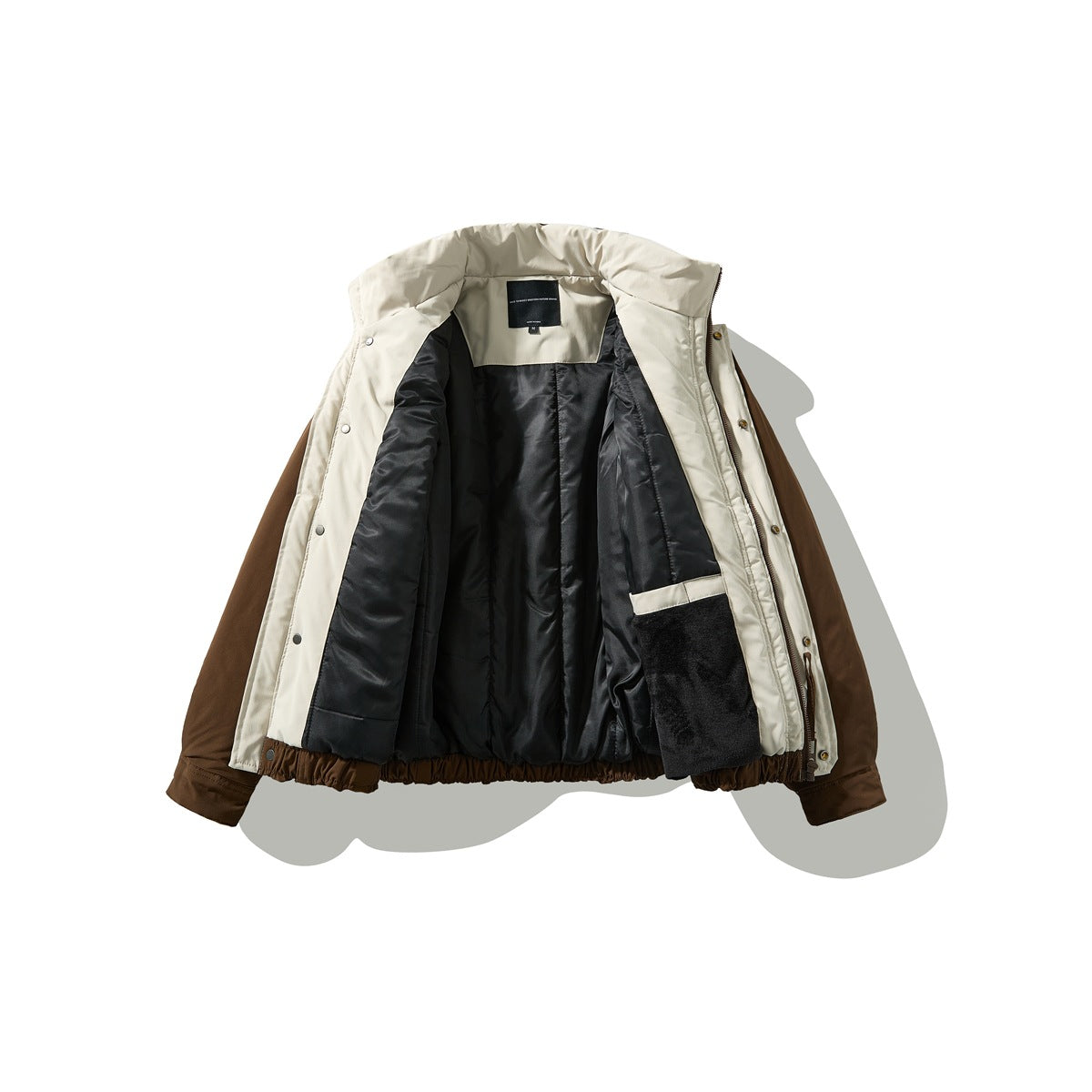 Open jacket showing a cream inner facing, black lining, a plush black interior pocket, and a small neck label.