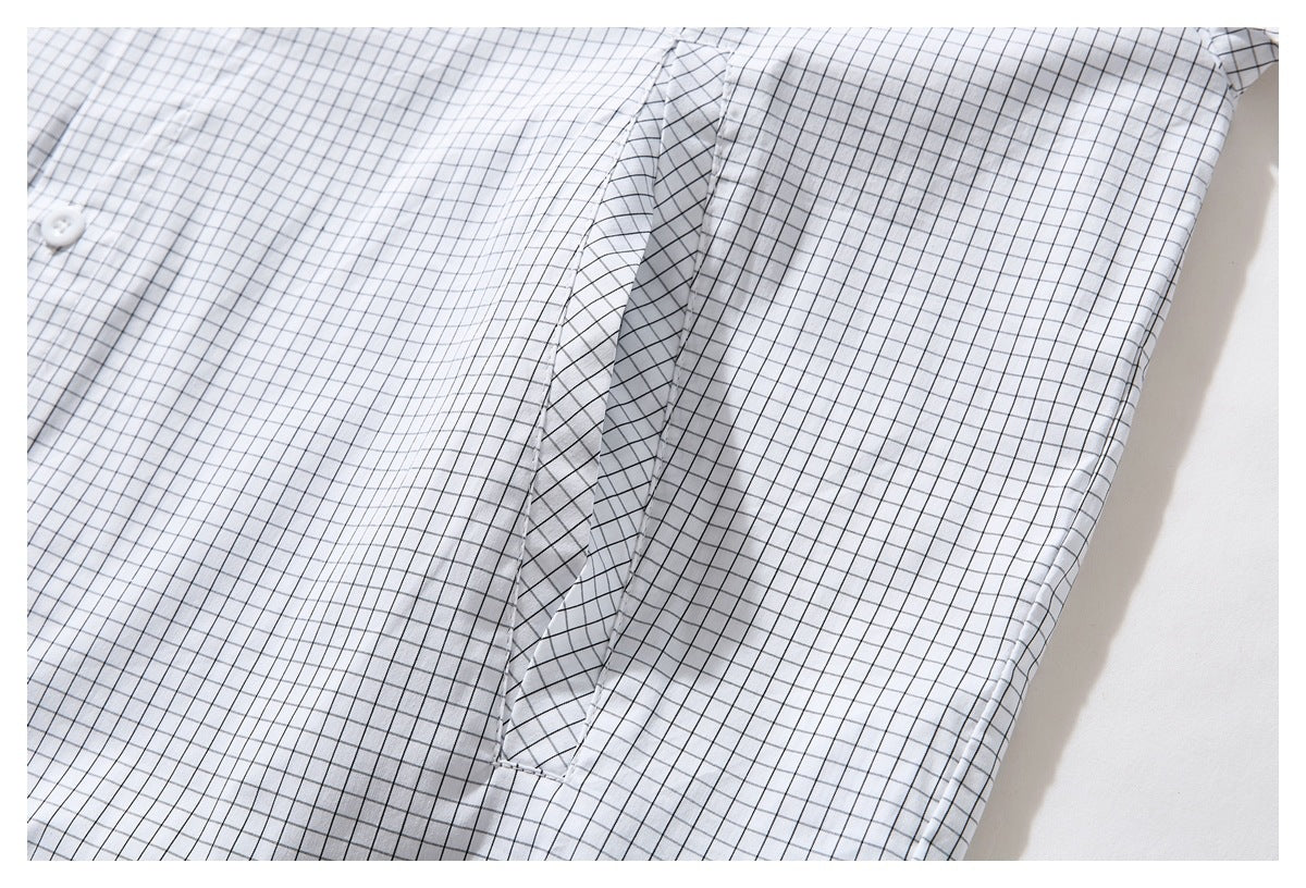 Close-up of the white shirt's black grid pattern and sleeve-to-body seam.