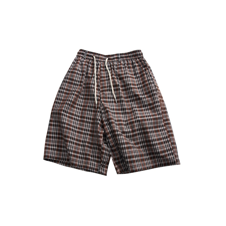 Brown and black plaid knee-length shorts with elastic waist and off-white drawstring, flat lay front view