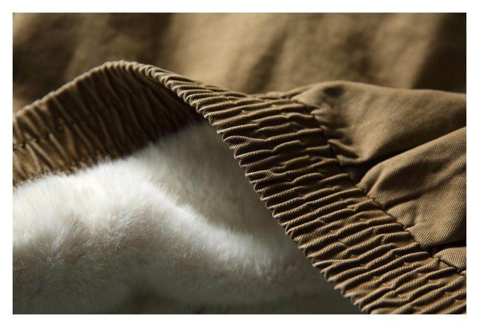 Close-up of a tan-brown garment edge with gathered stitching and soft white lining visible inside.