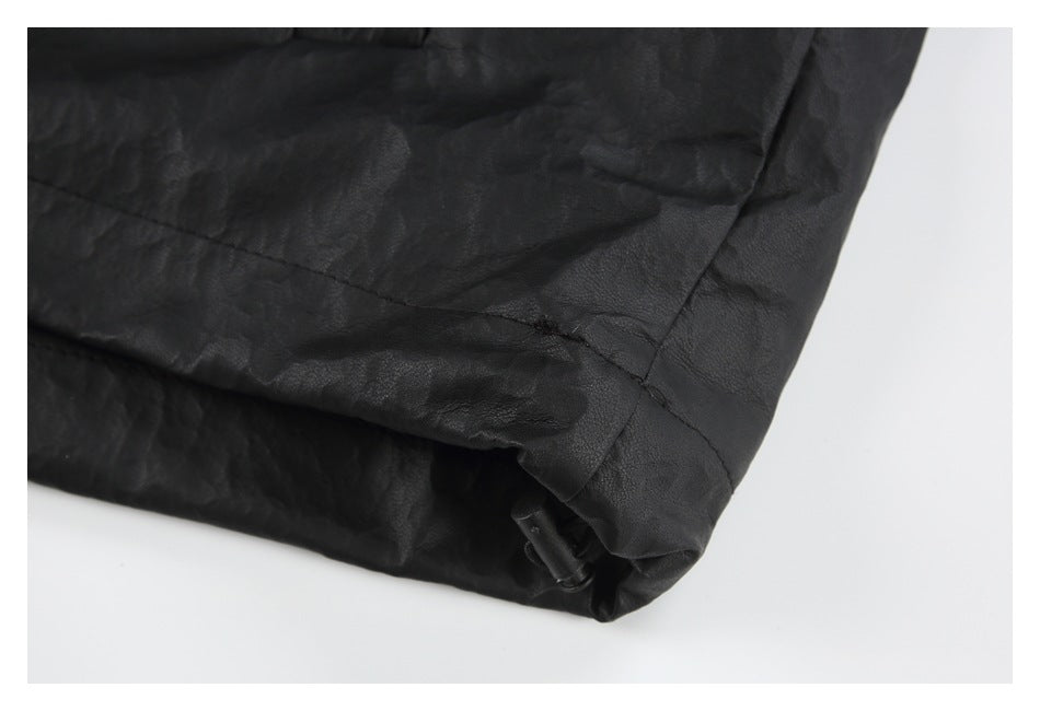 Close-up of the black jacket hem with a small adjustment toggle and visible stitching.