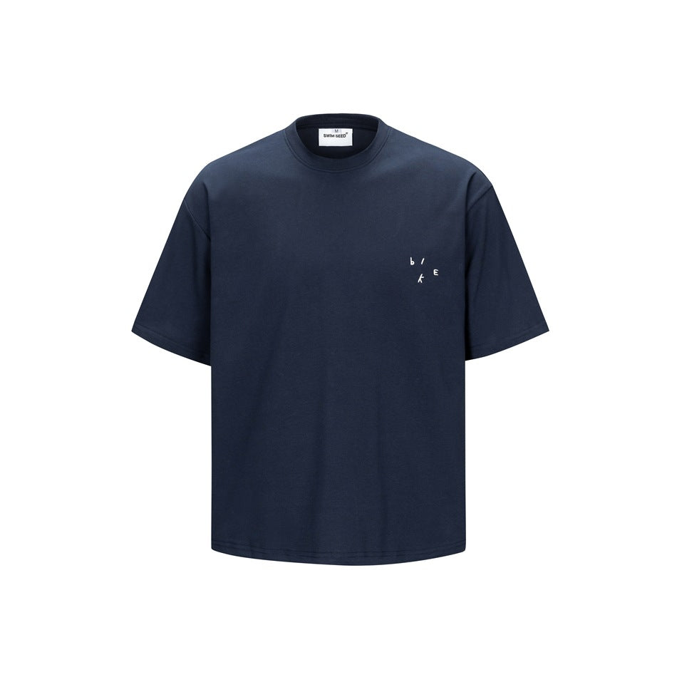 Navy short-sleeve crew-neck T-shirt, front view, with small white scattered-letter mark on left chest
