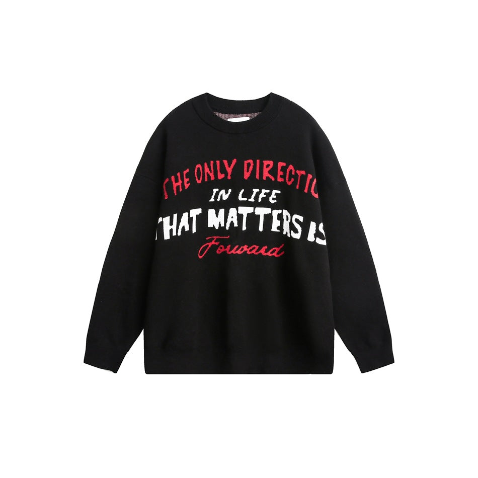 Front view of a black crewneck sweater with red and white English lettering across the chest.