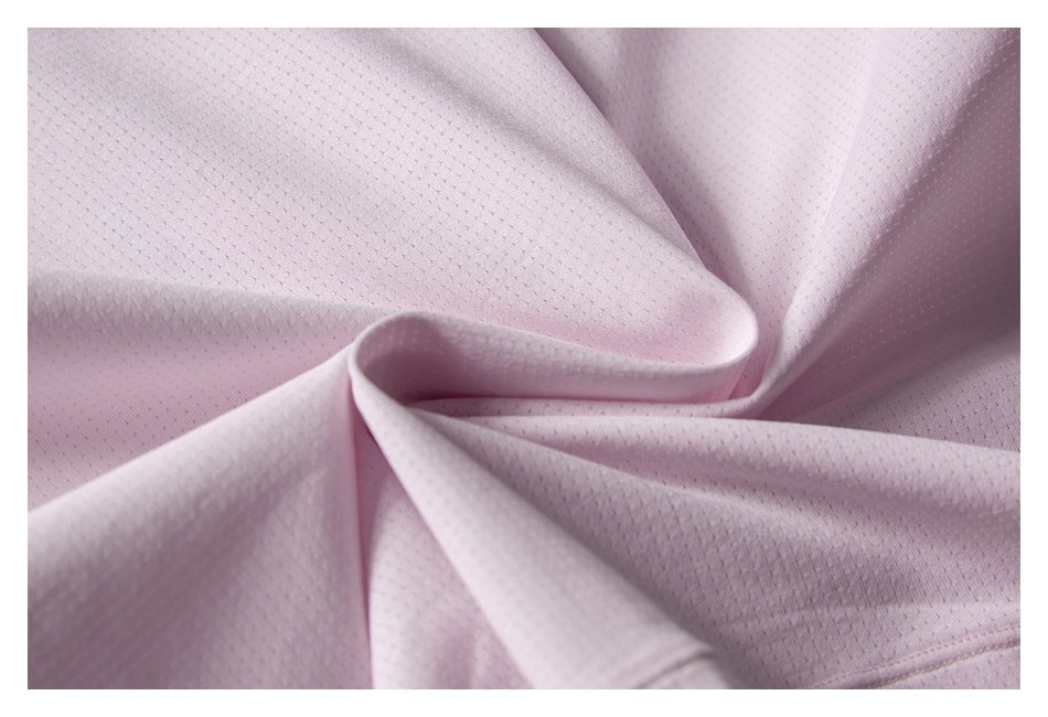 Close-up of pale pink perforated garment fabric arranged in soft folds.