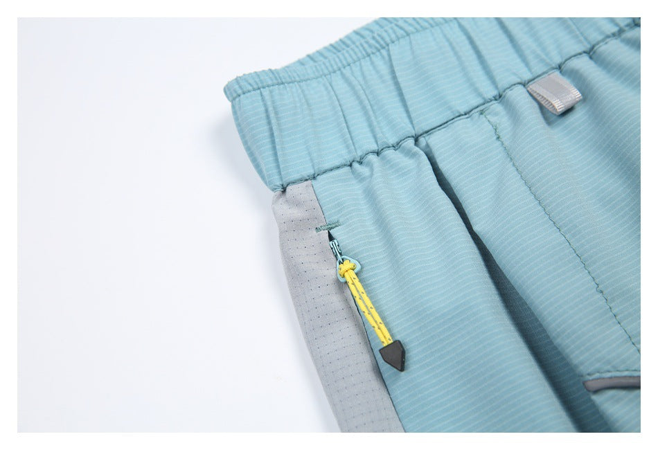 Close-up of the light blue skort's side zipper, yellow pull cord, gray pocket panel, and elastic waistband.