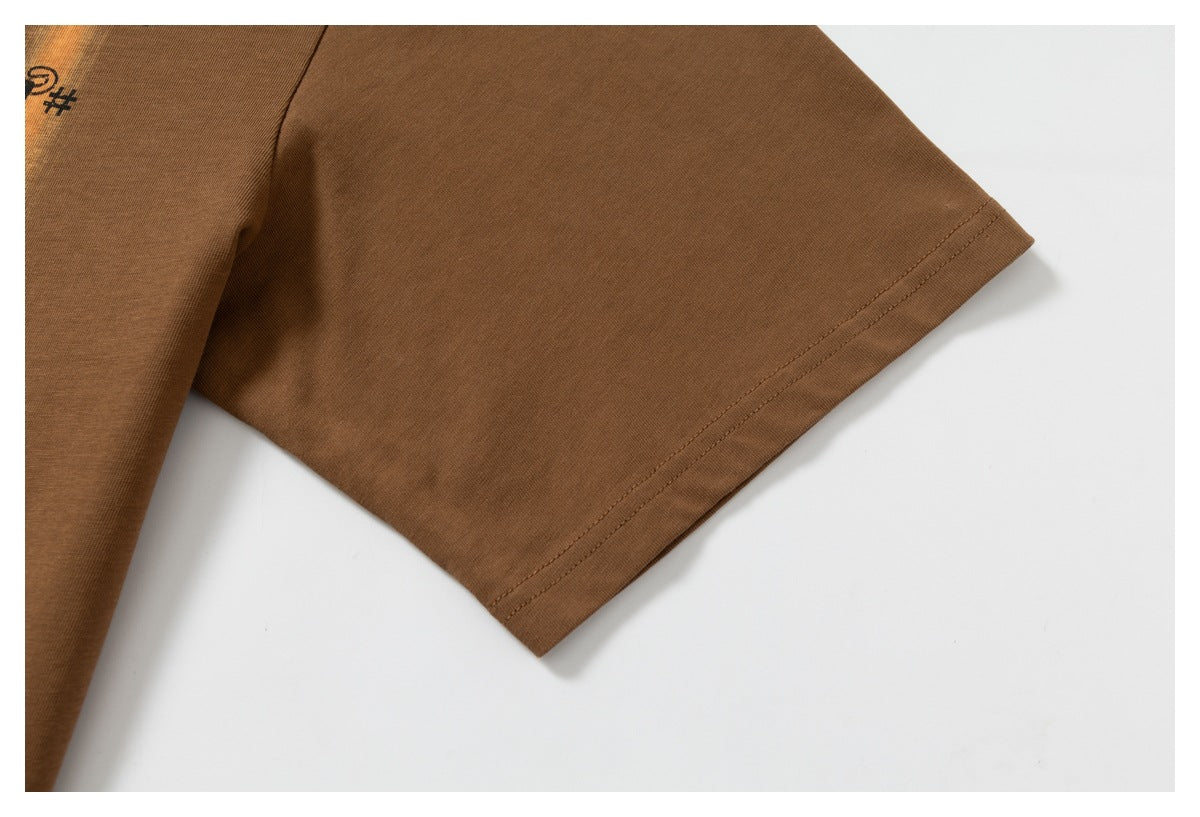 Close-up of the brown T-shirt sleeve hem and a small cropped portion of its black graphic print.