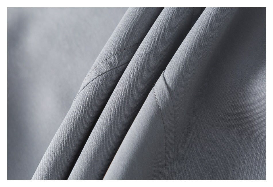 Close-up of folded light gray fabric showing its surface texture and stitching.
