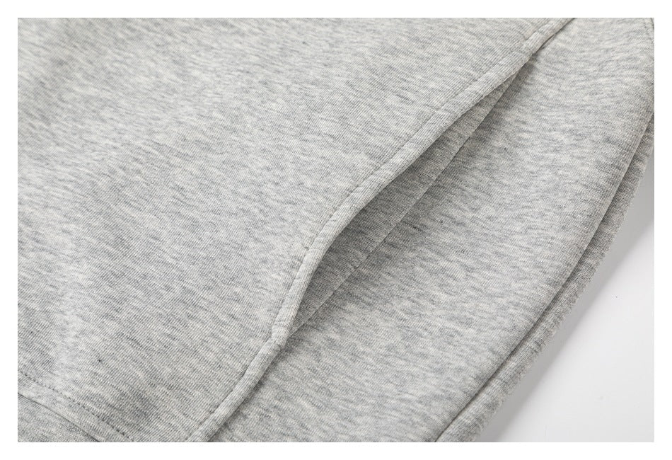 Close-up of the gray marled garment’s curved seam and folded edge.