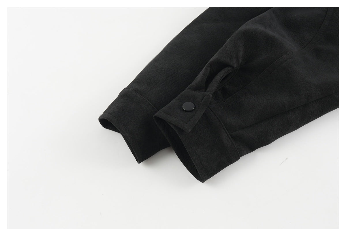 Close-up of the black jacket's sleeve cuff with a snap-adjustable strap.
