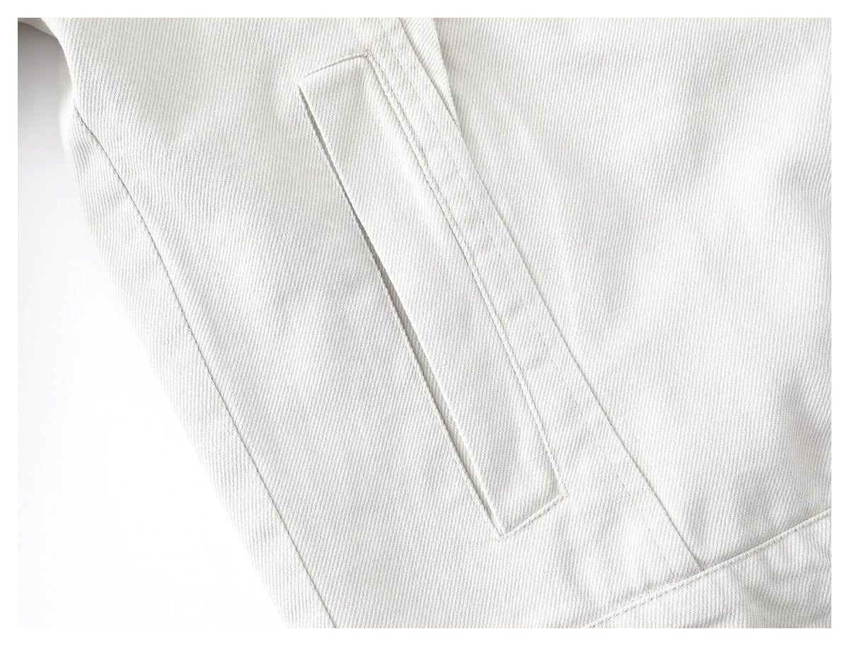 Close-up of a long, narrow welt pocket on the off-white jacket.
