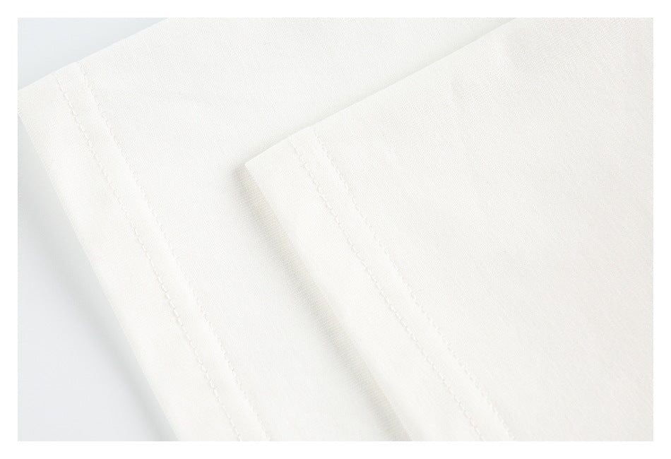 Close-up of an off-white garment edge with neat parallel stitching.