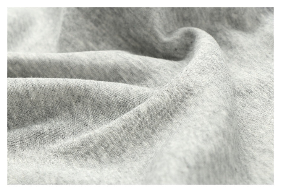 Close-up of softly folded heather-gray fabric showing its fine knit texture.