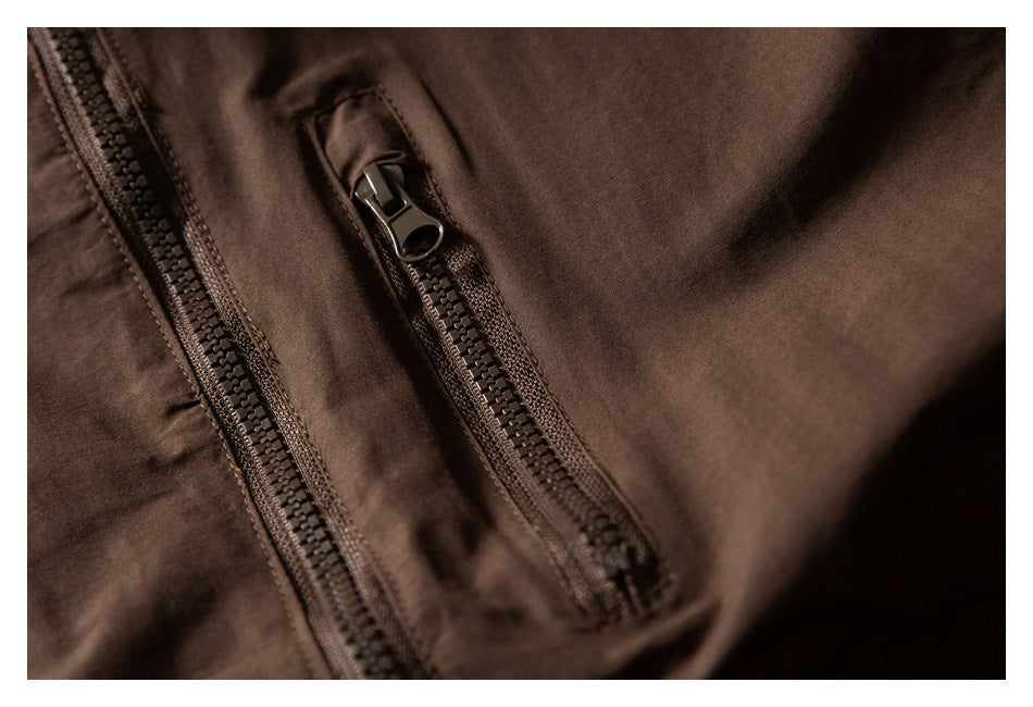 Close-up showing the main zipper and a smaller zip pocket on a dark brown jacket.