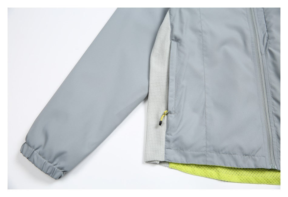 Close-up of a gray jacket sleeve, side panel, yellow-trimmed zipper, and bright lime lining.