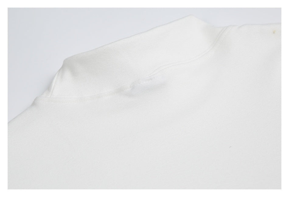 Close-up of a white garment's curved neckline seam and stitching.