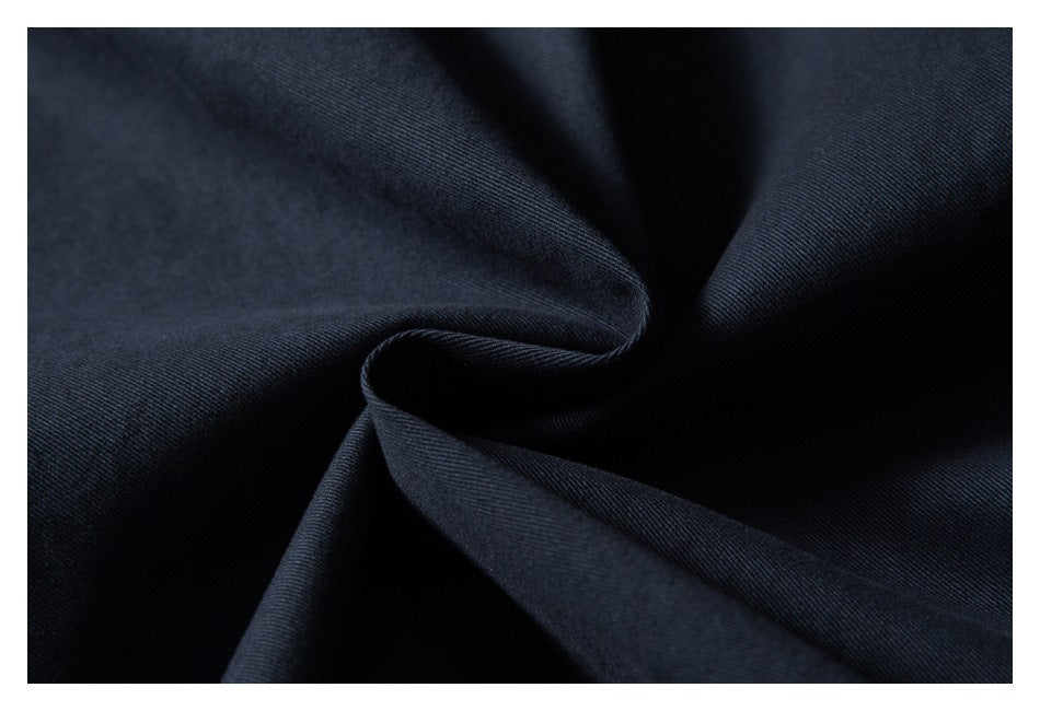Close-up of dark navy fabric draped into soft folds, showing its fine woven texture.
