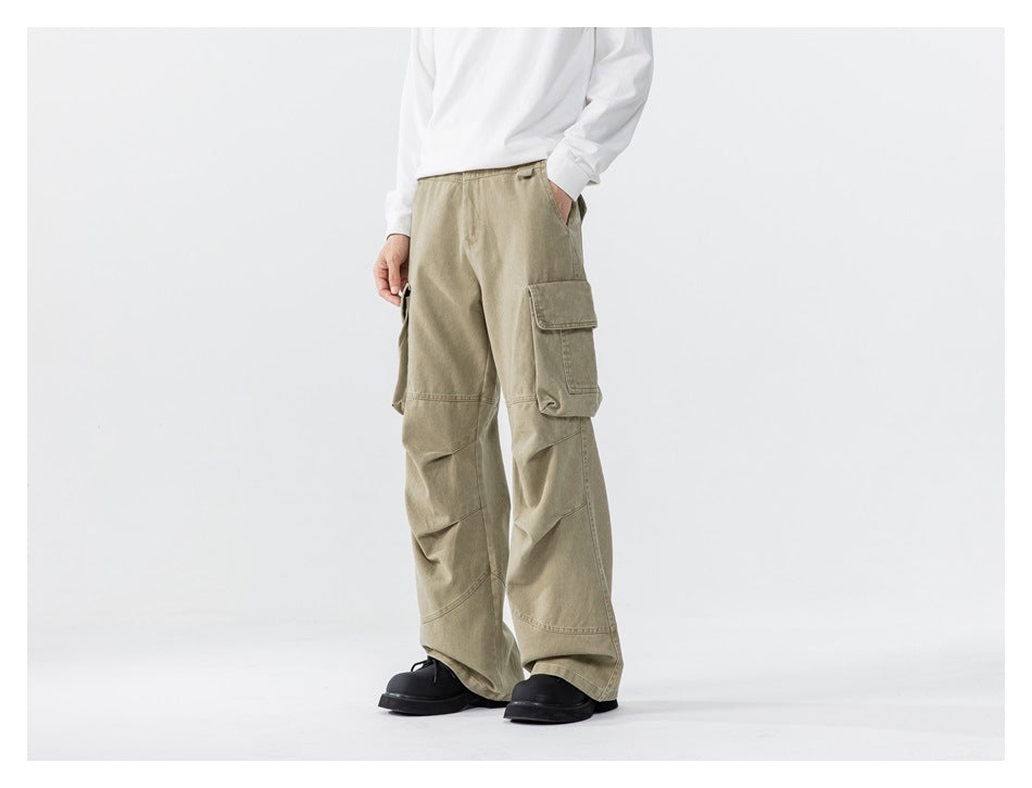 Model wearing loose olive-khaki cargo pants with large flap pockets and wide legs, front view.