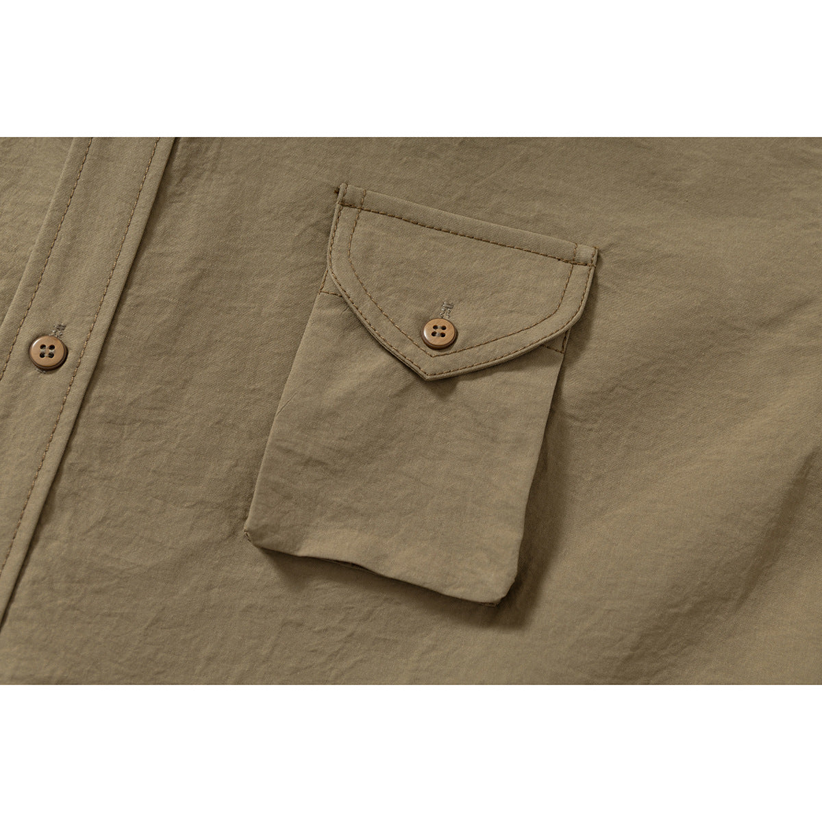 Close-up of a tan shirt's buttoned chest pocket and front placket.