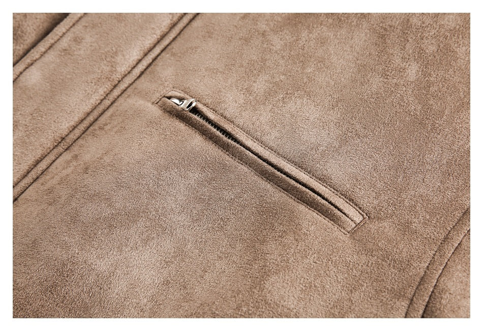 Close-up of a brown jacket's diagonal zippered pocket and stitched seams.