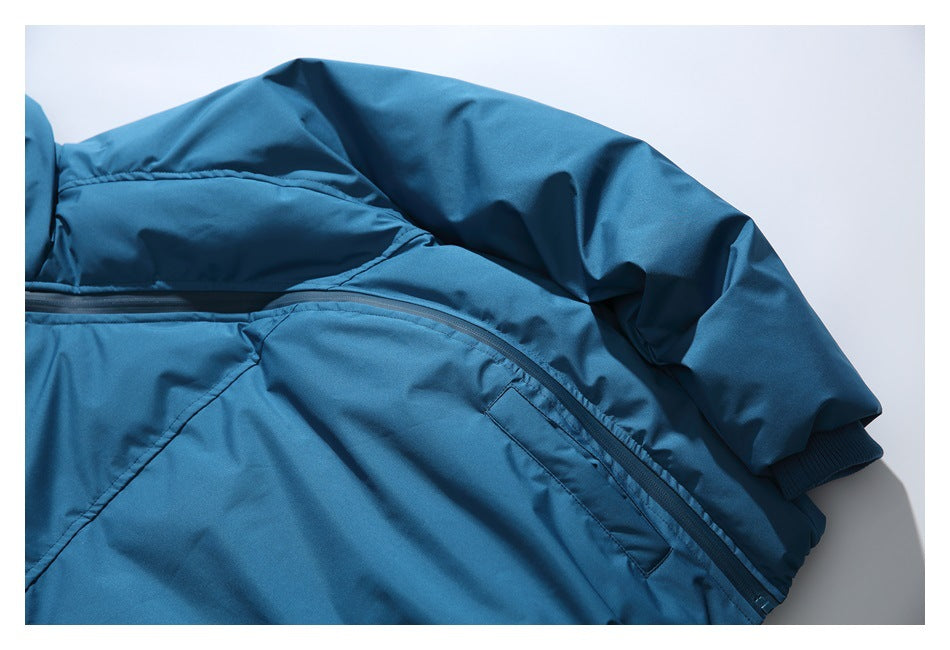 Close-up of a blue jacket sleeve, ribbed cuff, curved pocket zipper, and seam details.