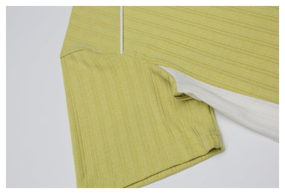 Close-up of the pale yellow shirt's short sleeve, underarm seam, and white side panel.