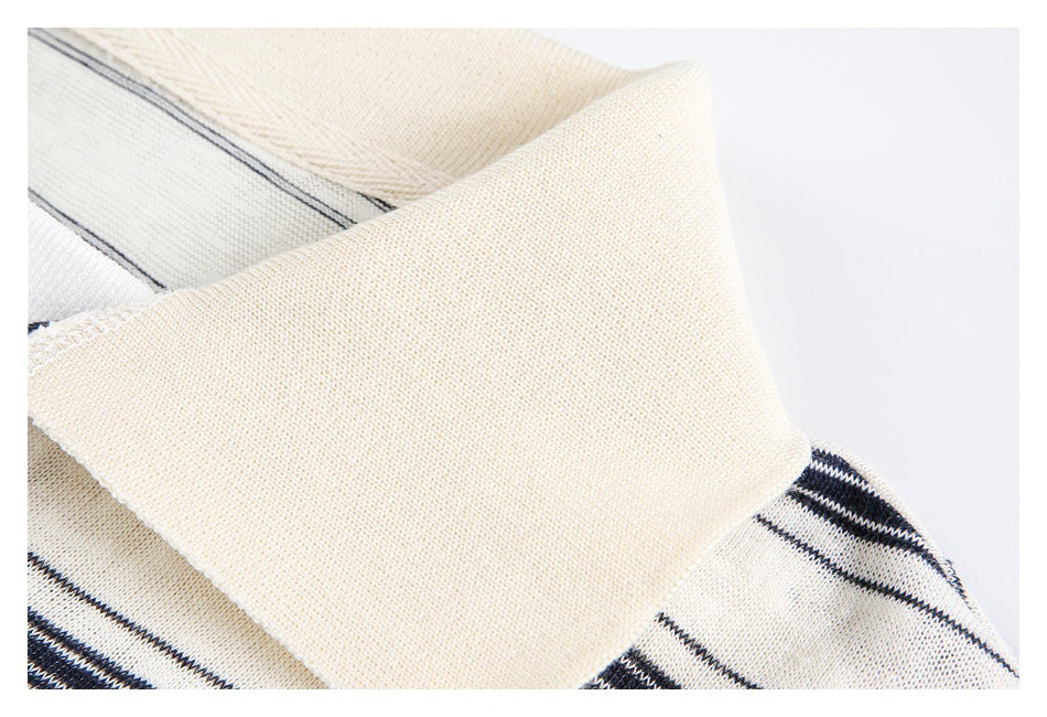Close-up of a wide cream collar against ivory fabric with narrow navy stripes.