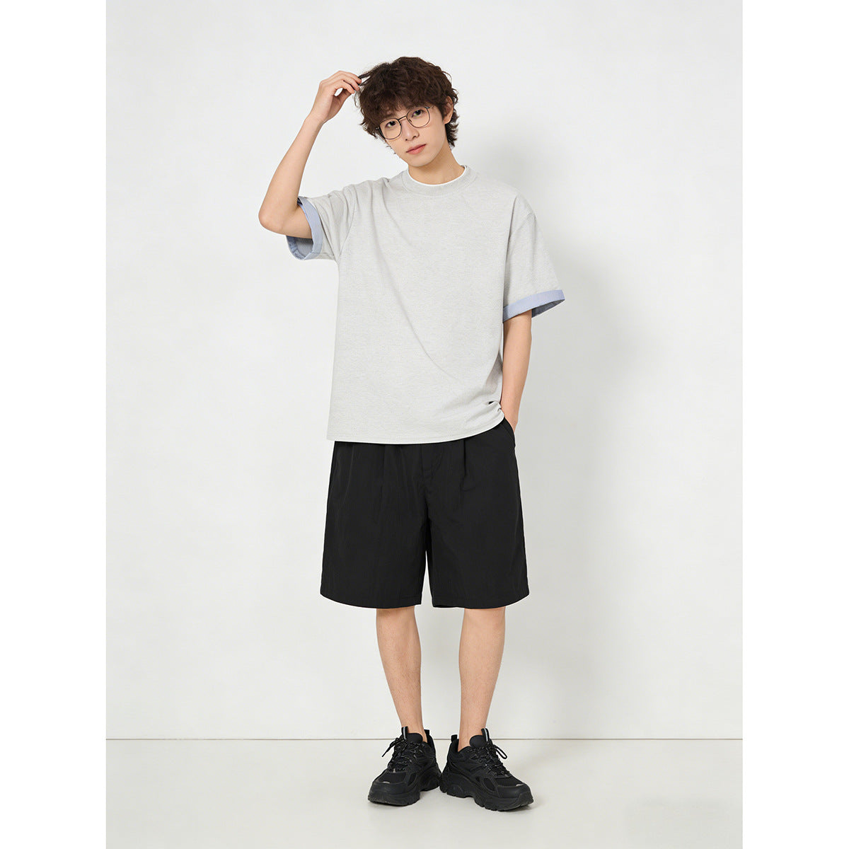 Model wearing a light gray short-sleeve crew-neck T-shirt with pale blue sleeve-cuff trim.