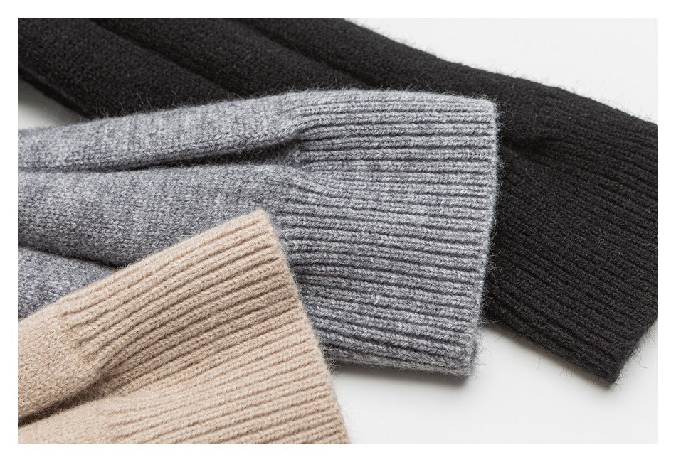 Close-up of ribbed sweater cuffs in black, gray, and beige, showing the knit texture.