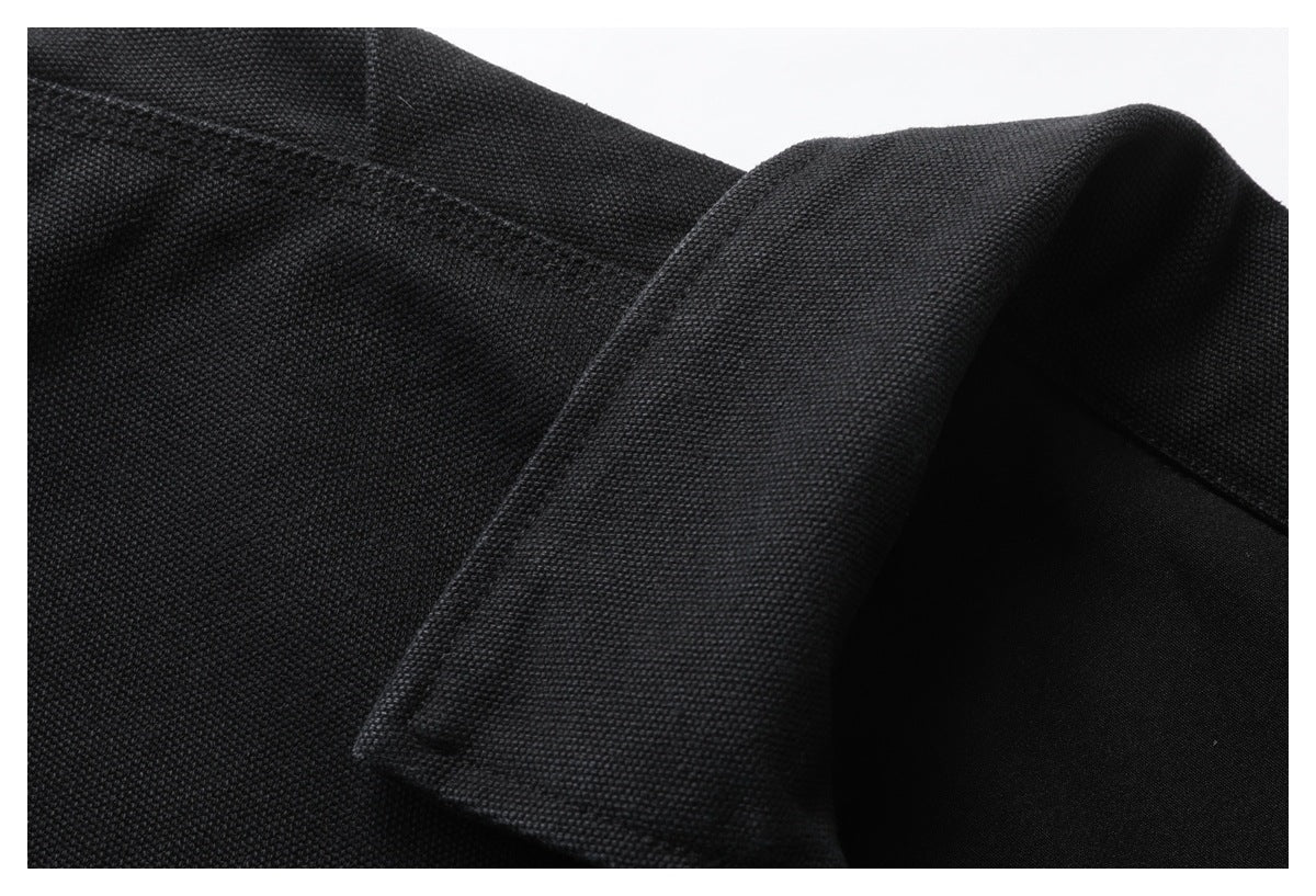 Close-up showing the textured black fabric and pointed collar of a jacket.