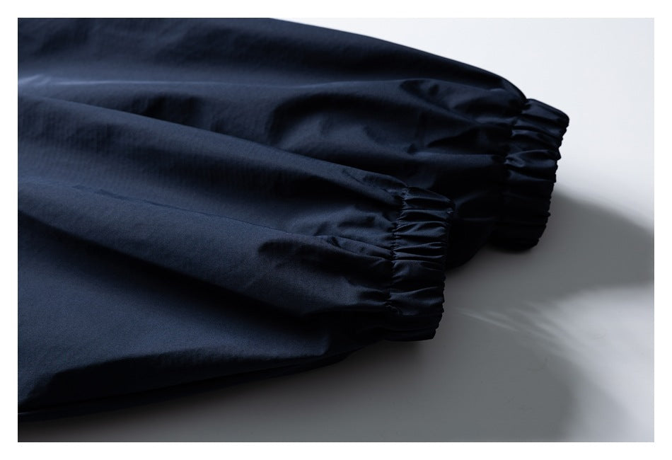 Close-up of navy jacket sleeves ending in gathered elastic cuffs.