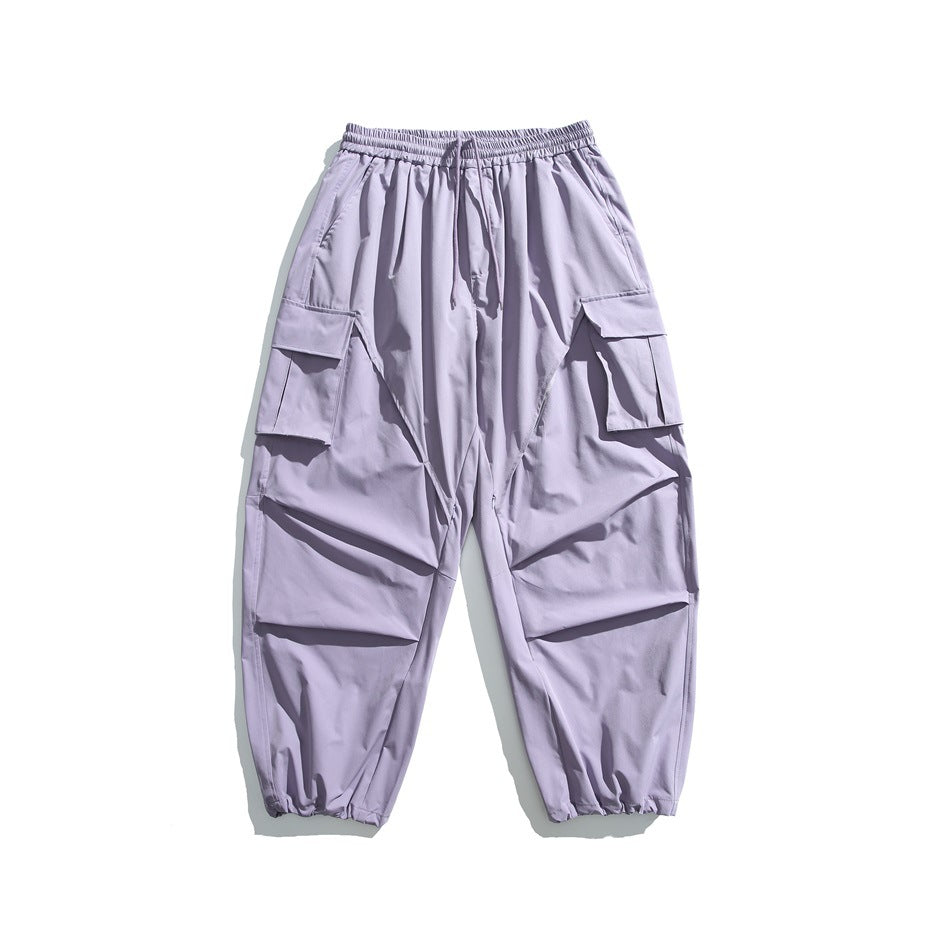 Light purple wide-leg cargo pants with drawstring waist, flap thigh pockets and gathered hems, flat lay