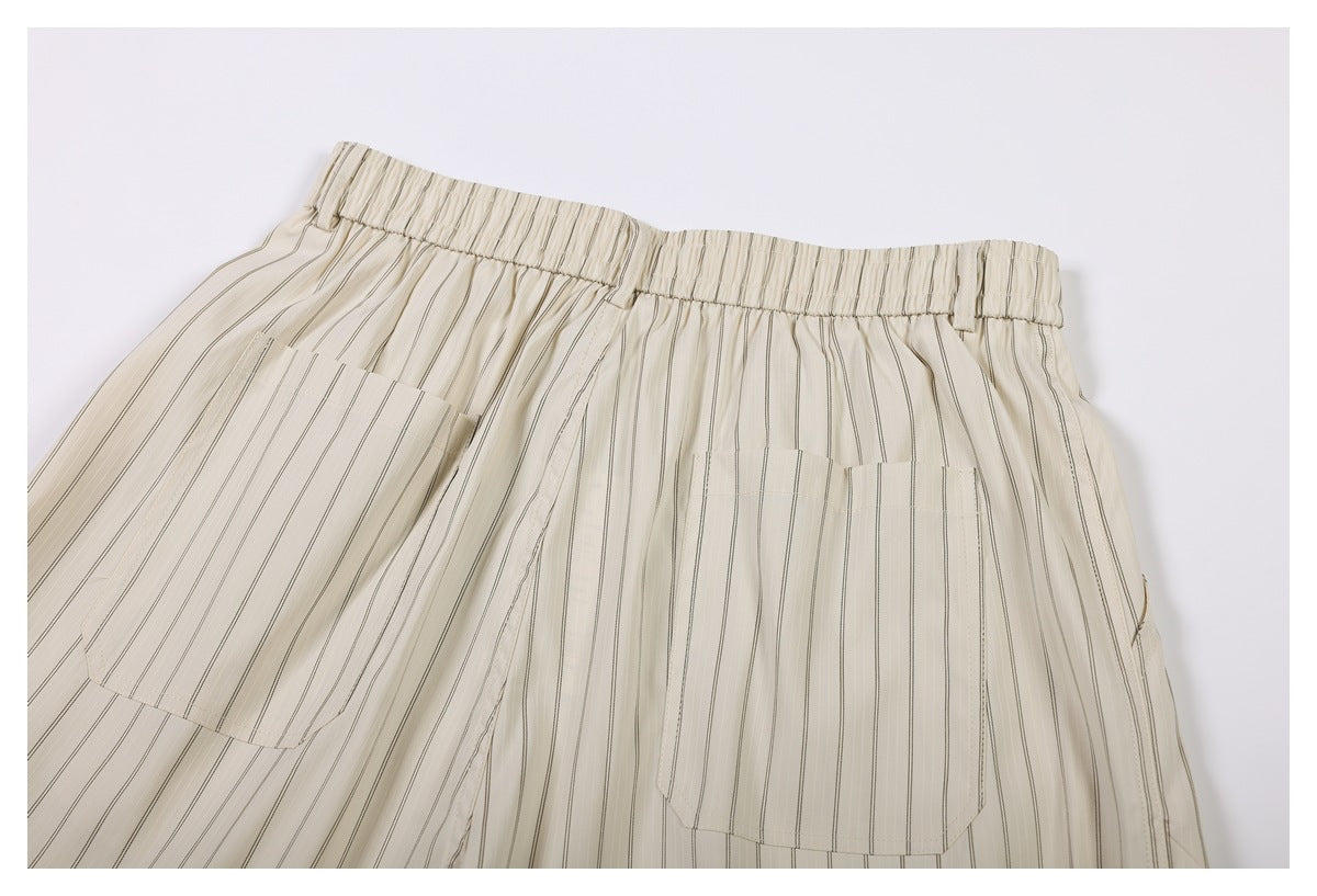 Back view of cream striped trousers with a gathered elastic waist and two large patch pockets.