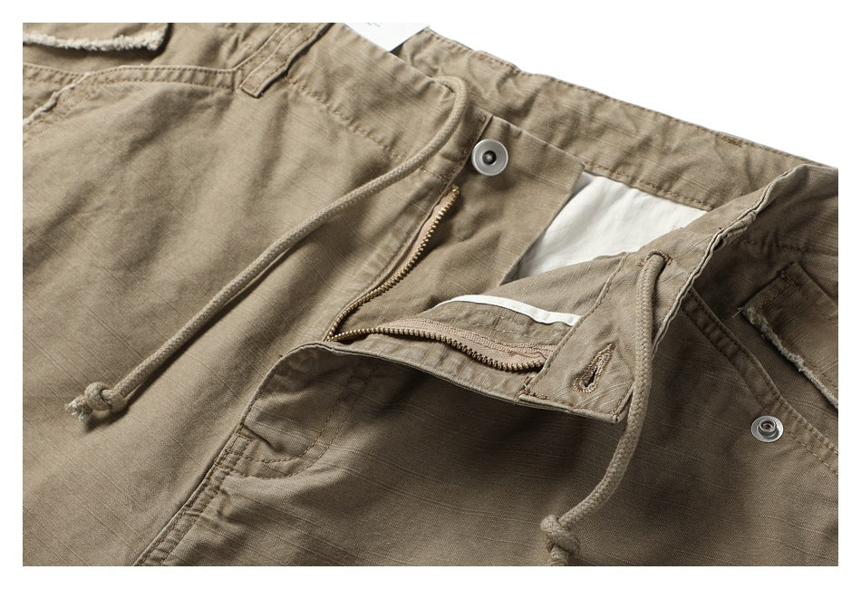 Taupe shorts shown open at the waistband, with a zipper fly, metal snaps, and drawstrings.