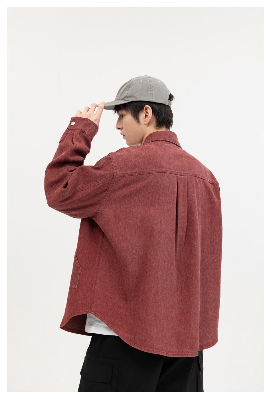 Close rear view of a model wearing a burgundy shirt with a back yoke and center pleat.