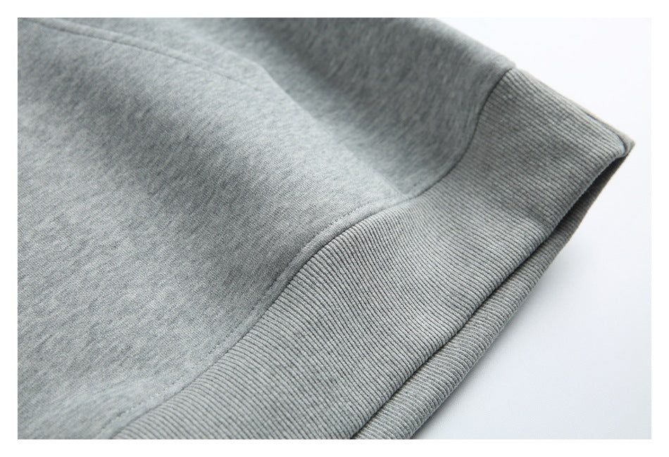 Close-up of the heather gray hoodie’s ribbed bottom hem and seam.