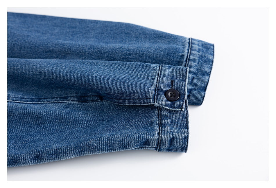 Blue denim sleeve cuff with a black button and buttoned tab.